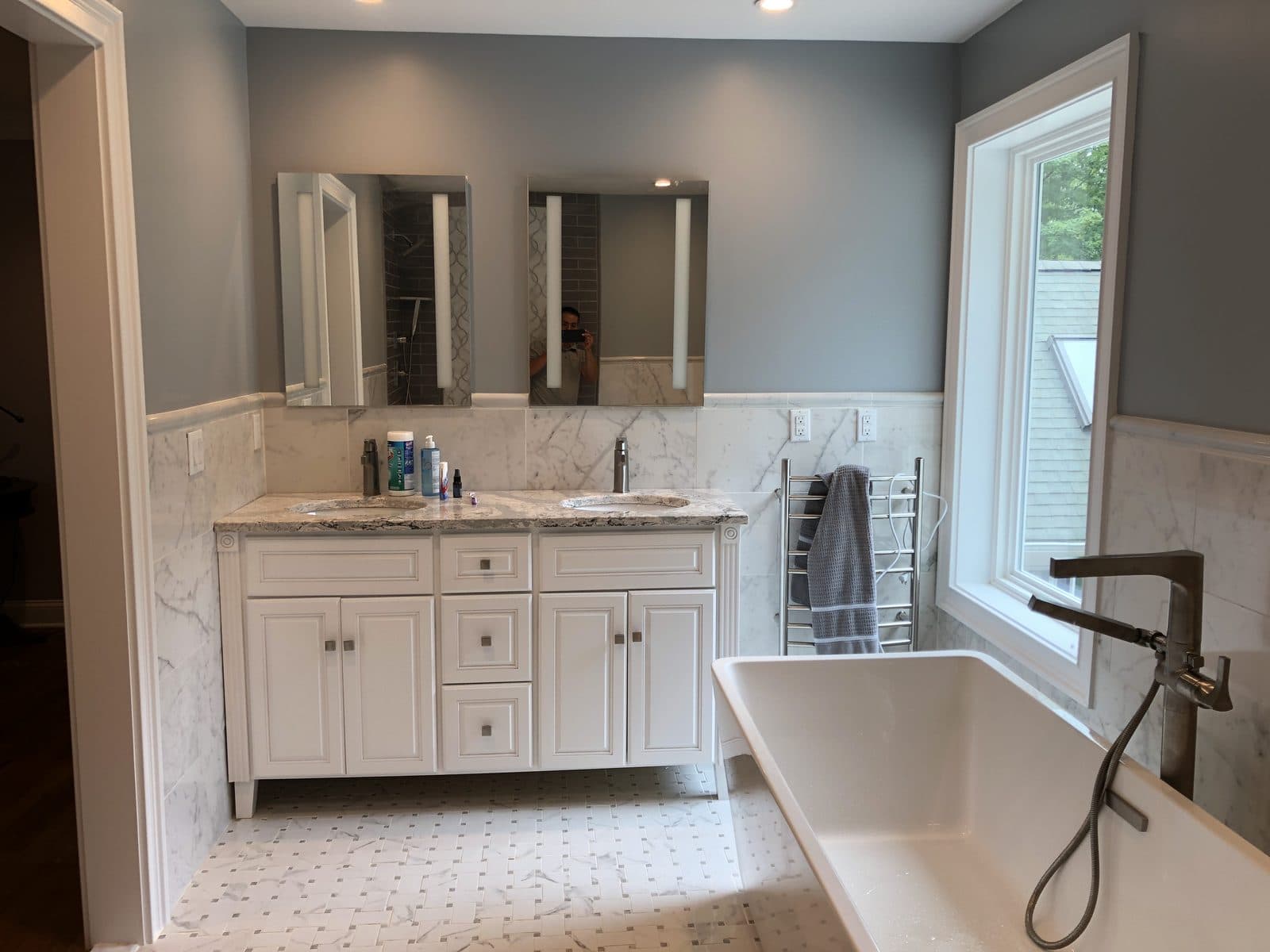 Renovated bathroom with double vanity and freestanding tub