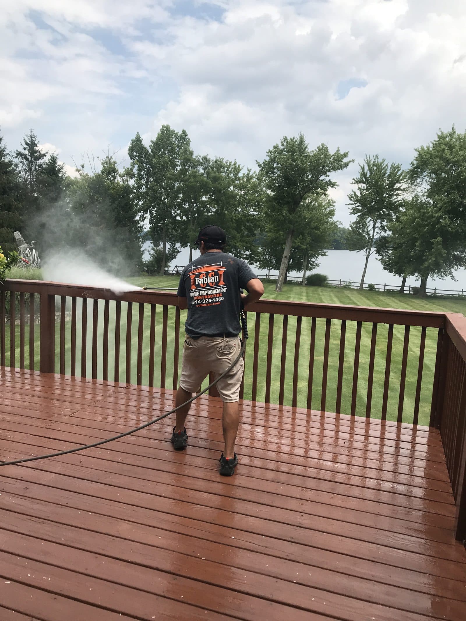Worker staining wood deck