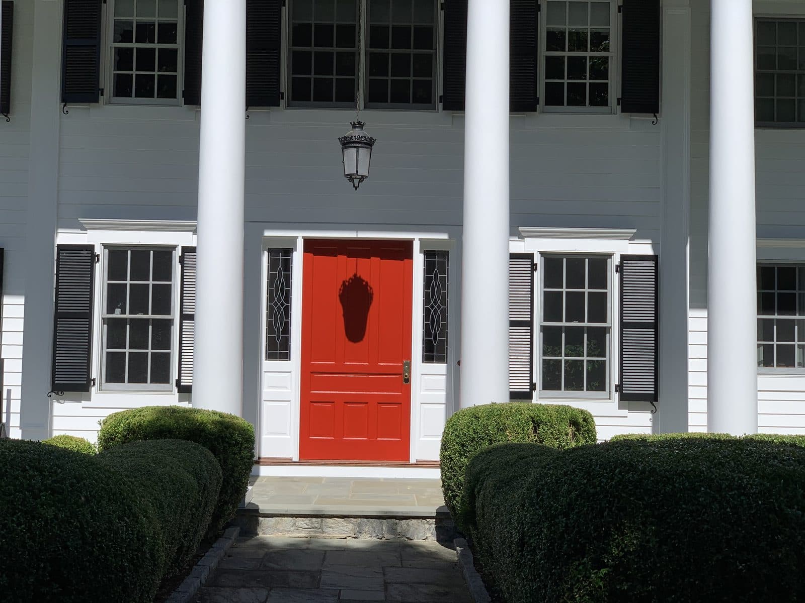 White house with columns and red door