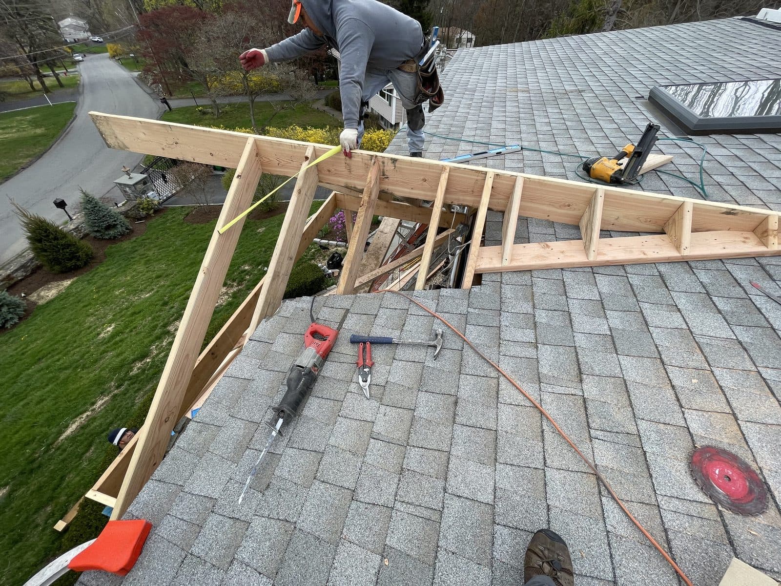 Workers installing roof shingles