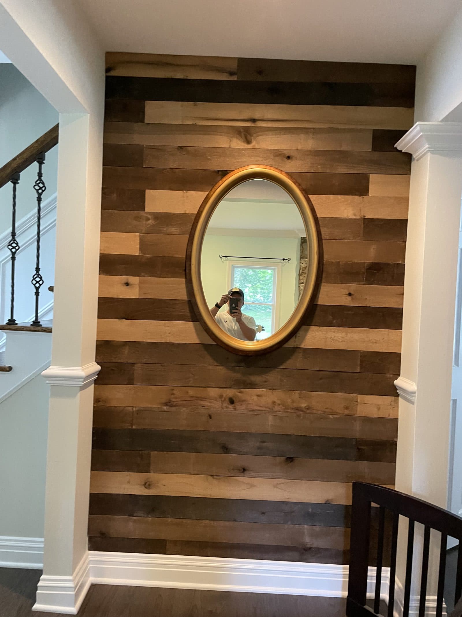 Wood accent wall with round mirror