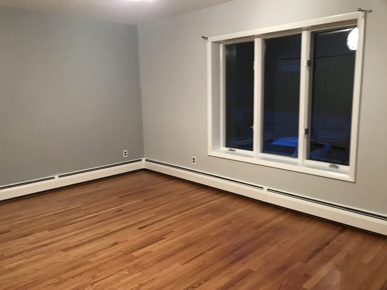 Empty room with gray walls and wood floor