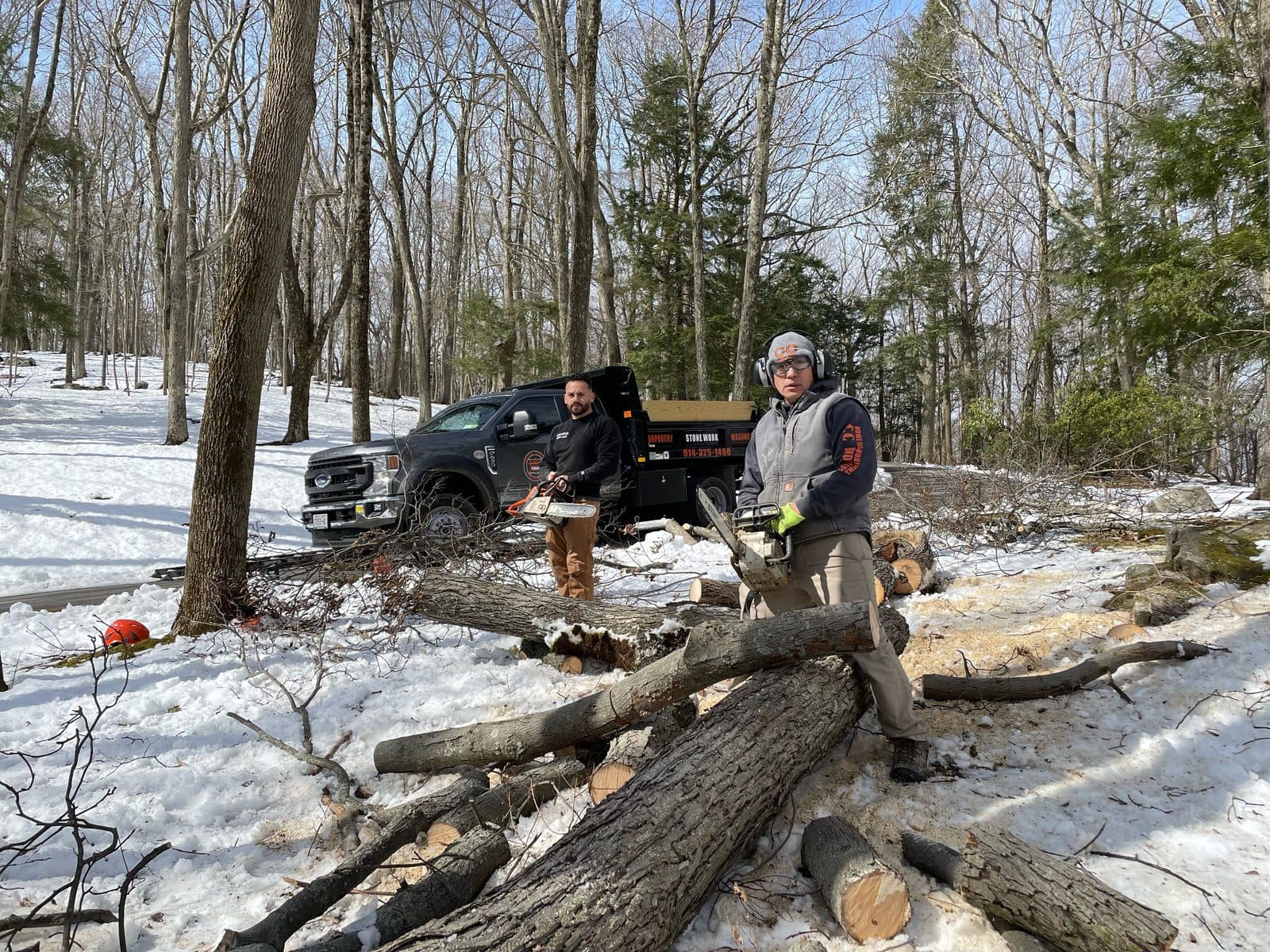 Crew member clearing fallen trees and brush for removal