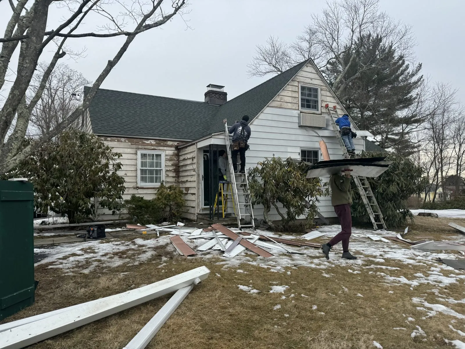 House exterior with snow and worker