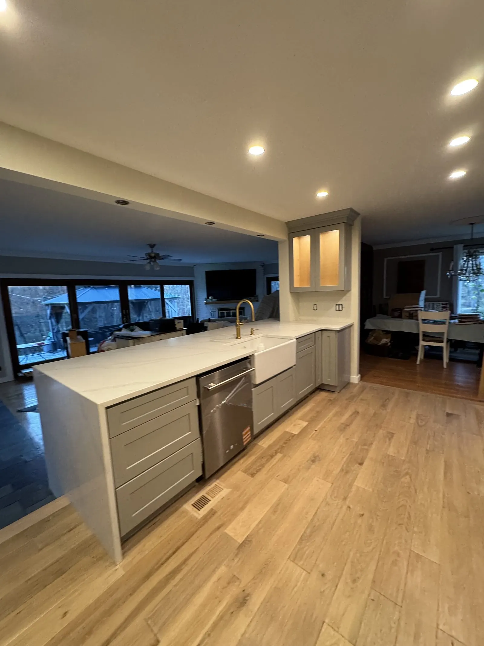 Long run of gray cabinetry with quartz counters and hardwood flooring