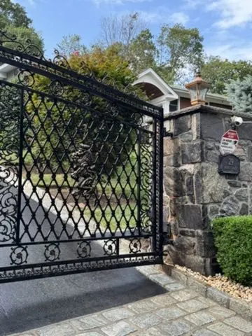 Custom iron double driveway gate with stone columns