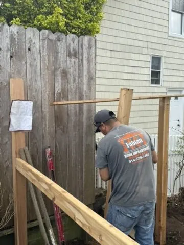 CC Fabian crew member building a wood fence