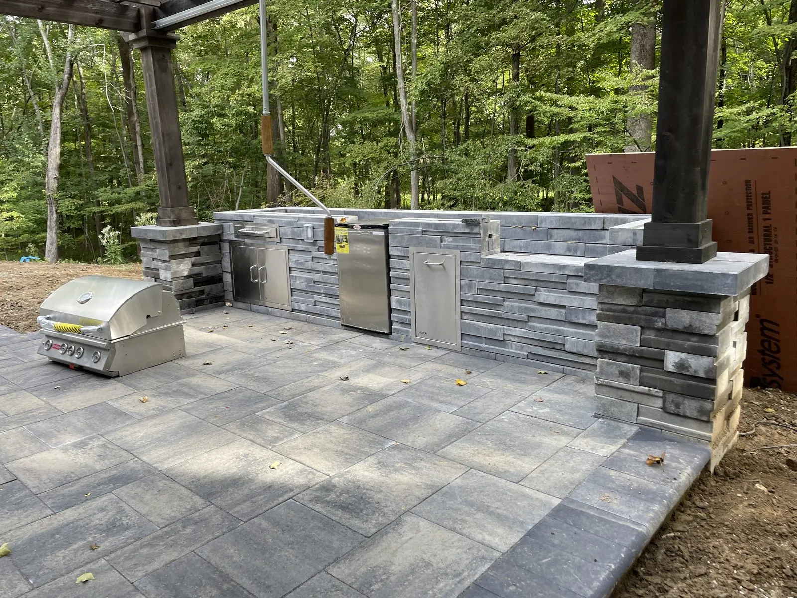 Covered outdoor kitchen with stone patio