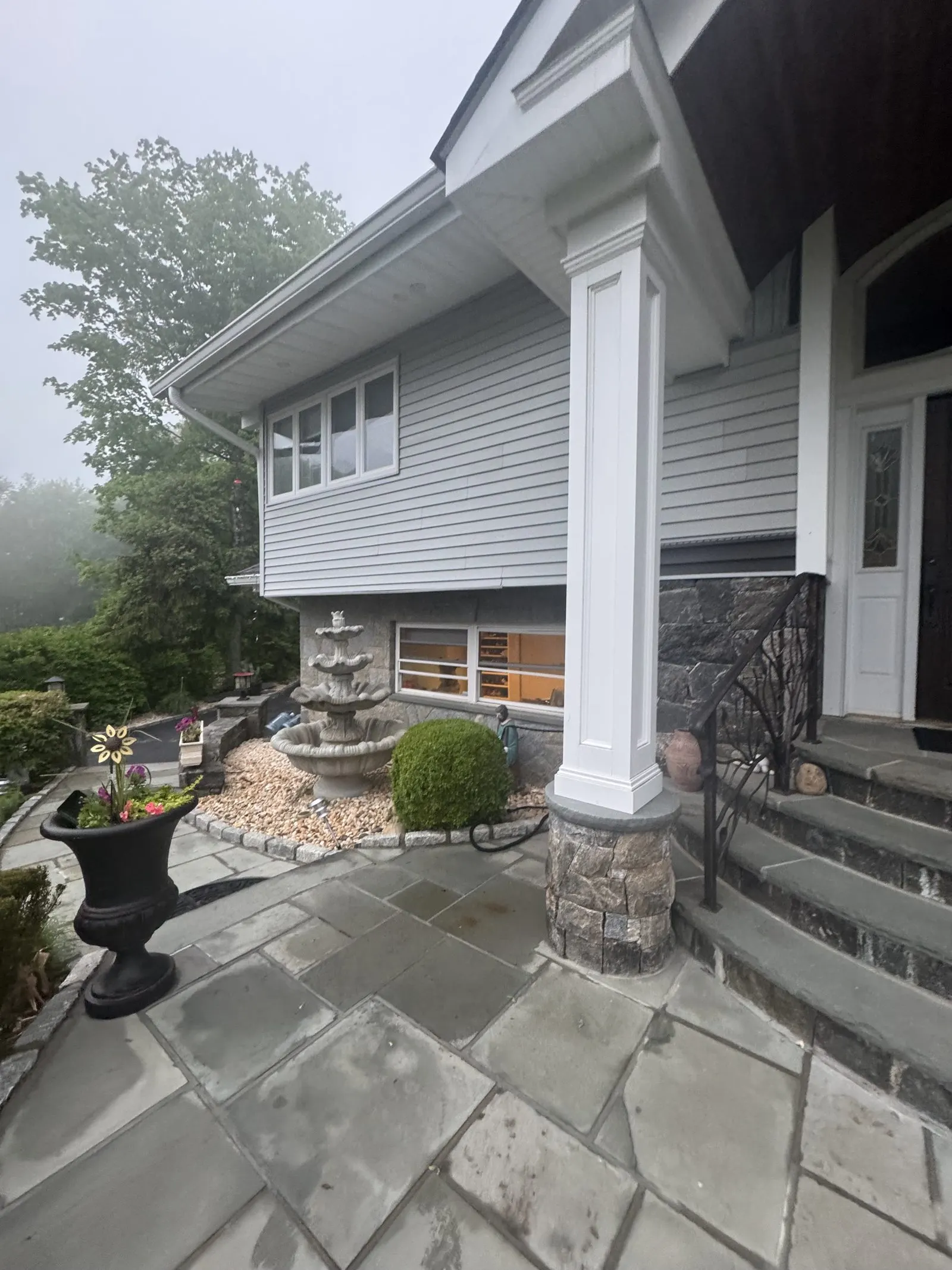 Gray-sided home with white columns and a bluestone patio