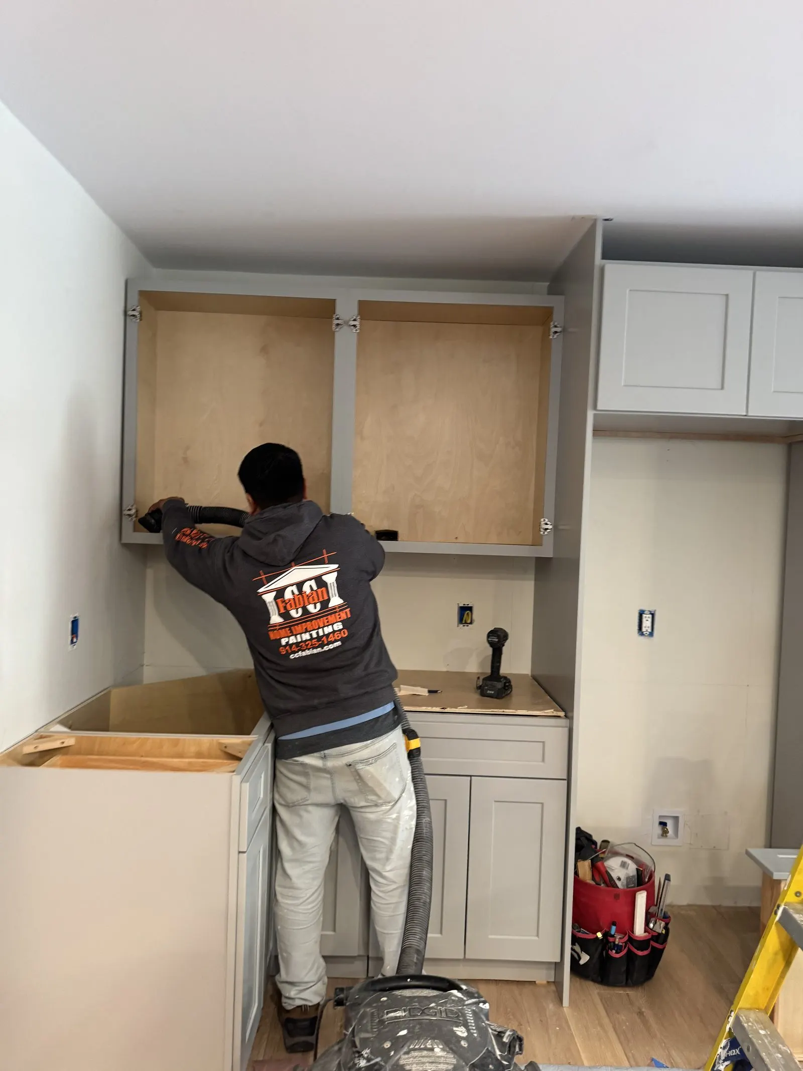 CC Fabian carpenter installing custom kitchen cabinetry.