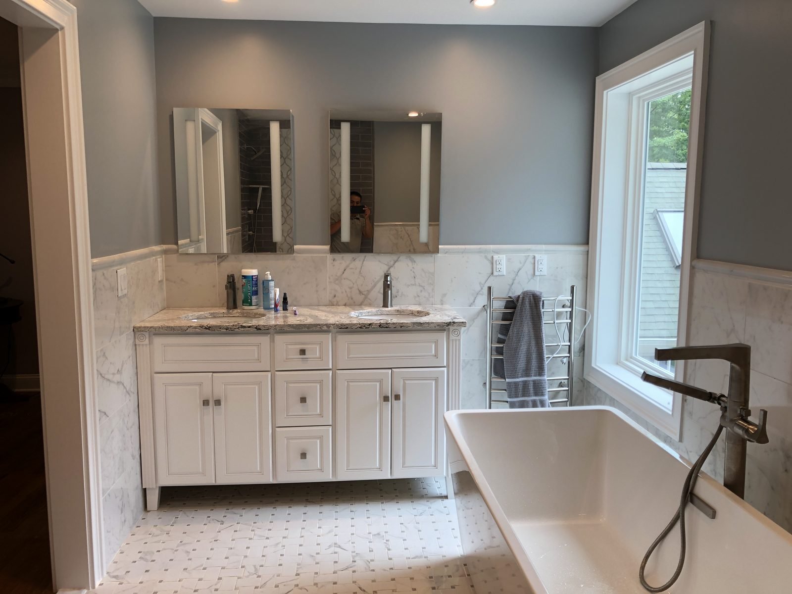 Renovated bathroom with double vanity and freestanding tub
