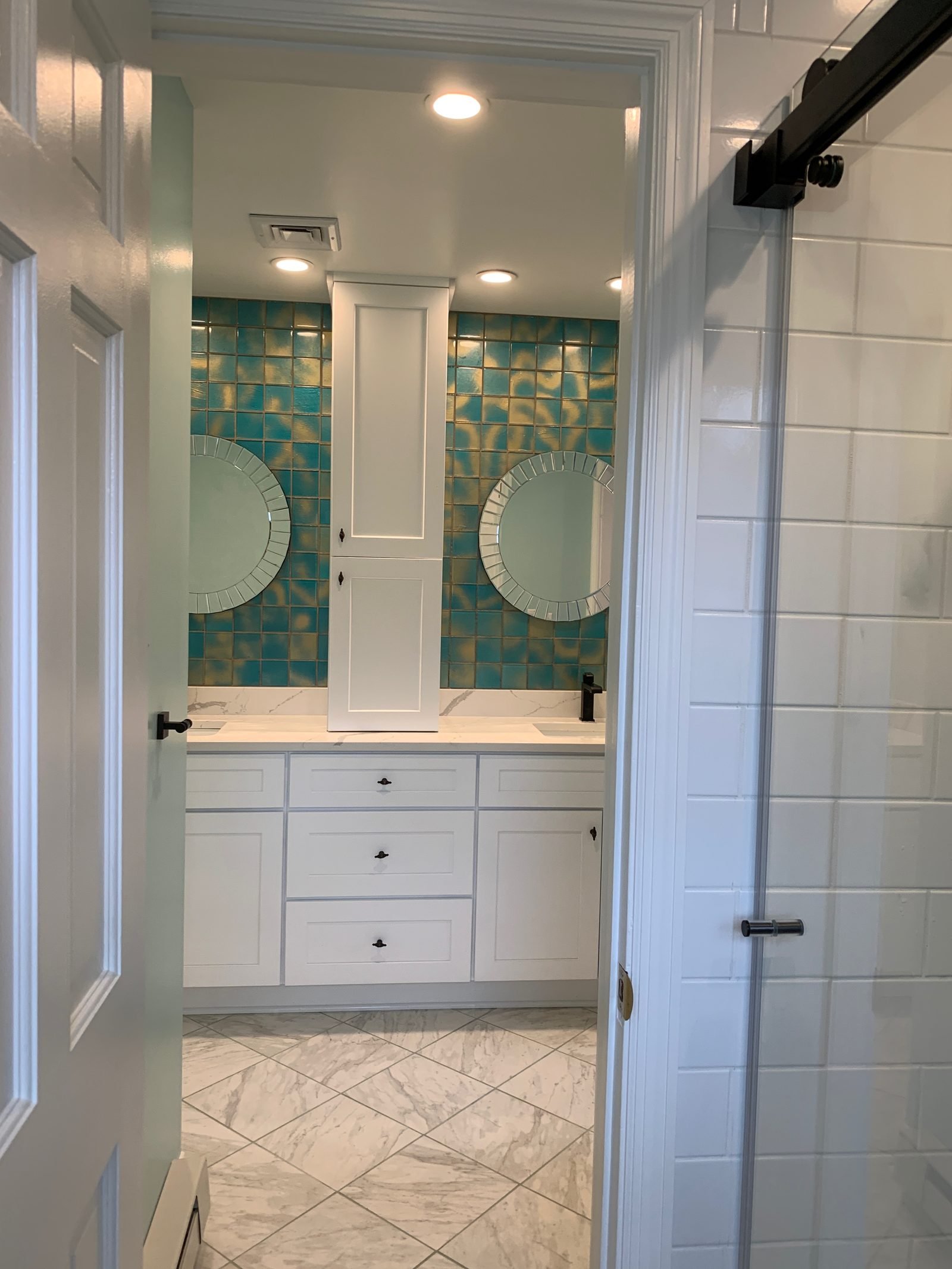 Completed bathroom with double vanity and marble-look floor tile