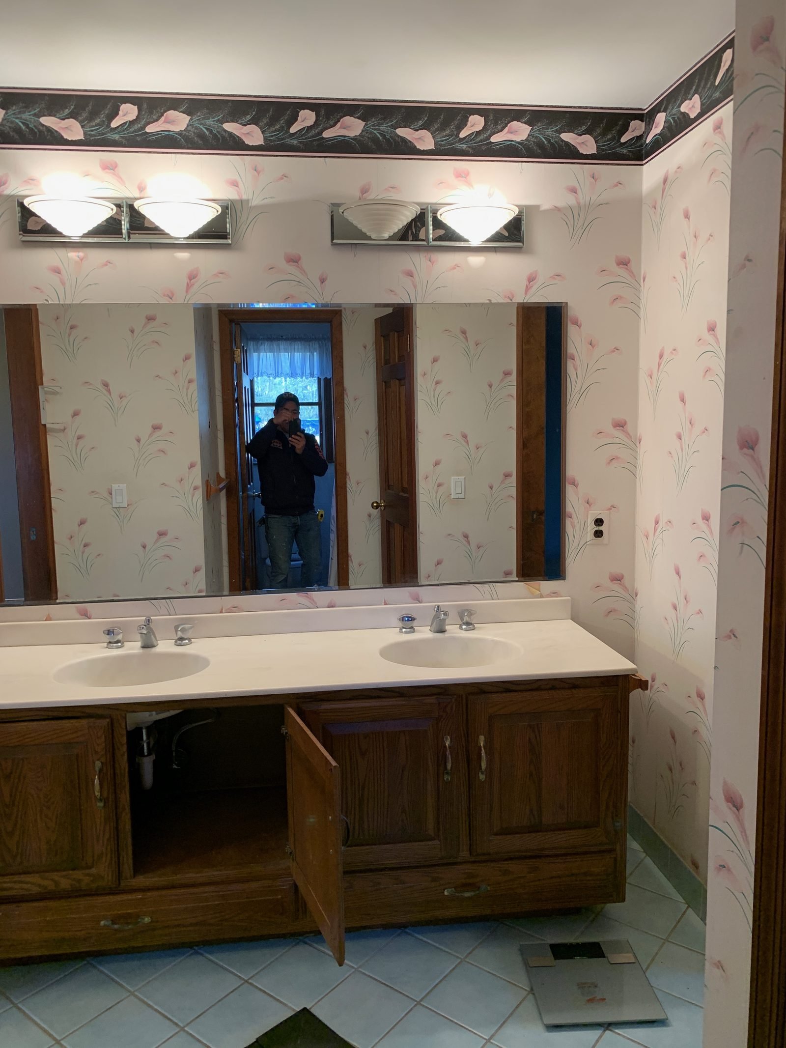 Dated bathroom with floral wallpaper and oak vanity before renovation