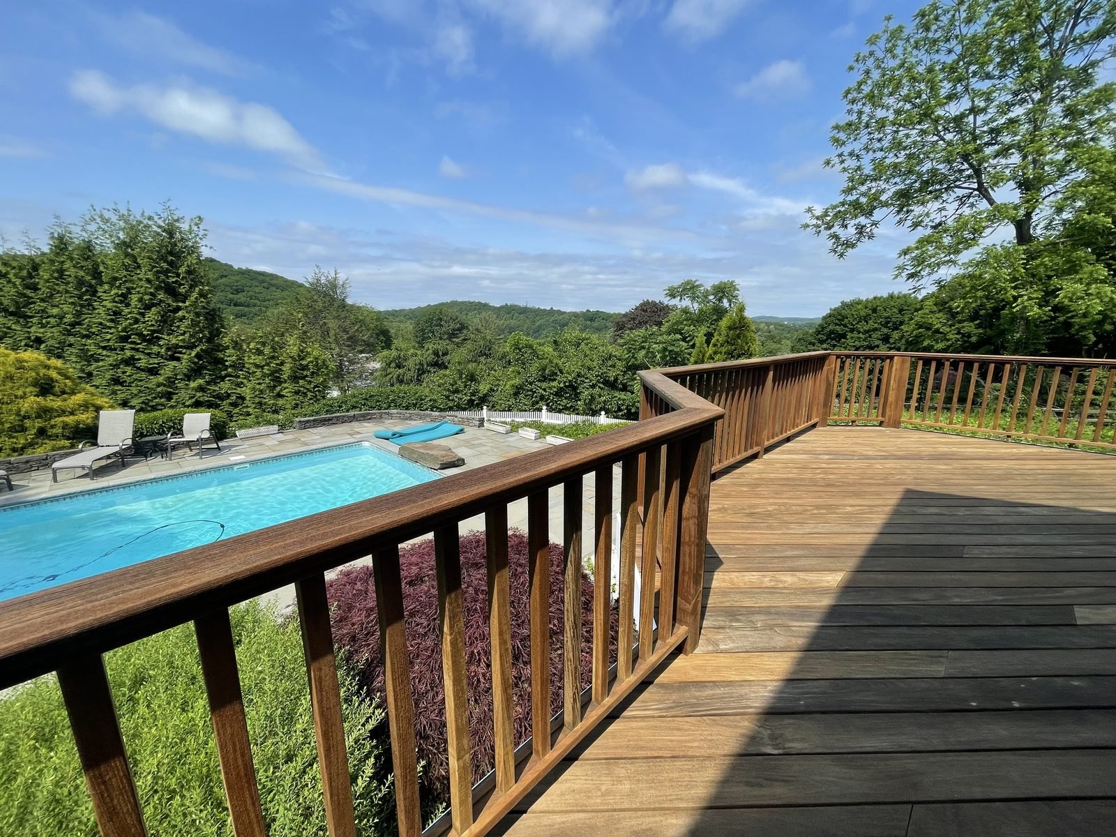 Stained wood deck overlooking a pool and the Putnam County hills