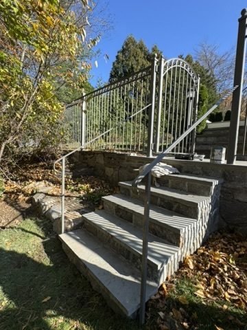 Wrought-iron railing along curved stone steps