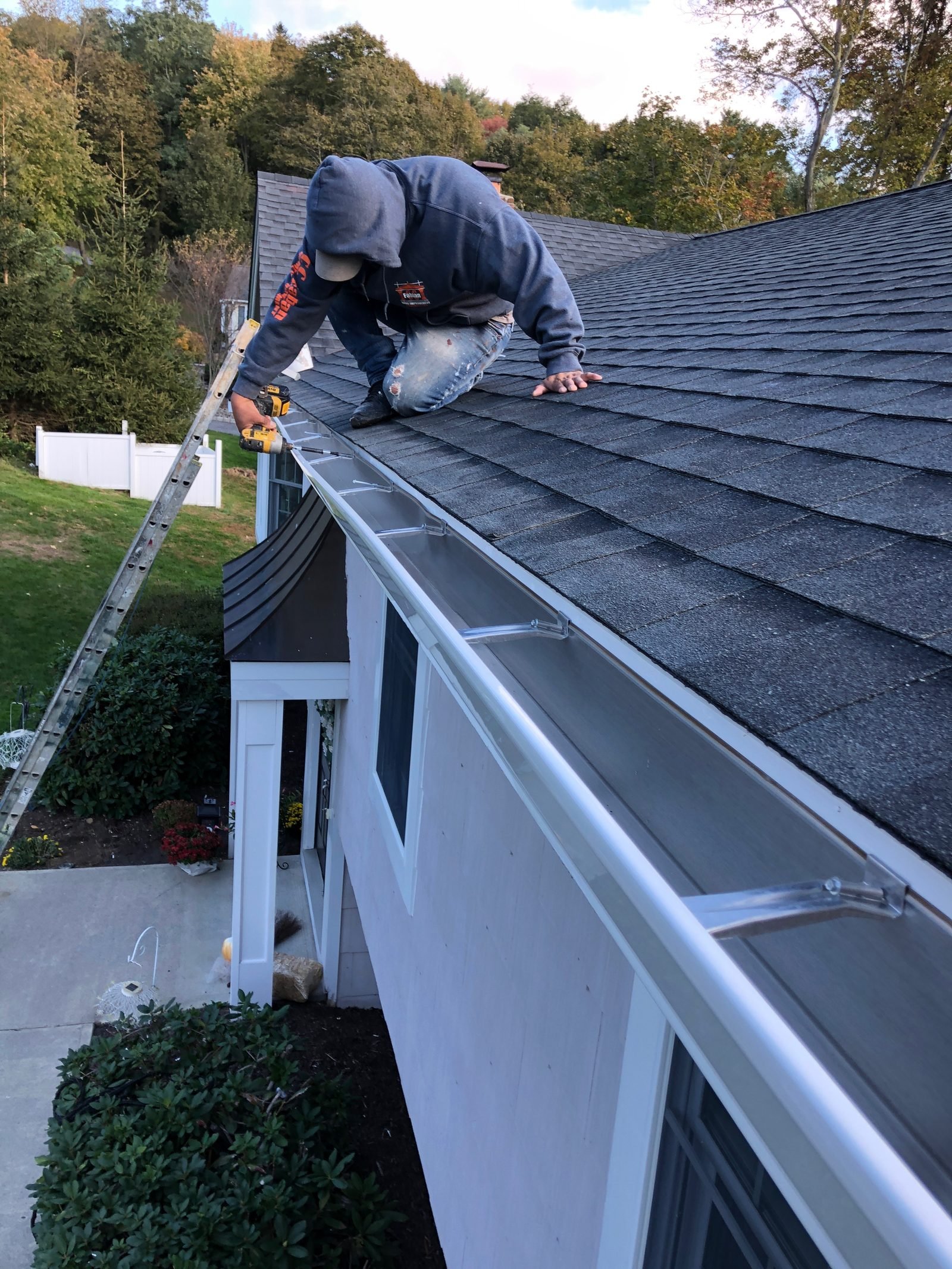 CC Fabian crew member installing a new gutter along a roof edge.