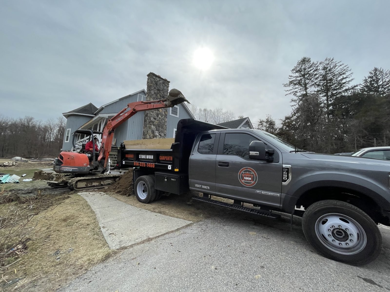 CC Fabian crew hauling away construction debris with a dump truck.