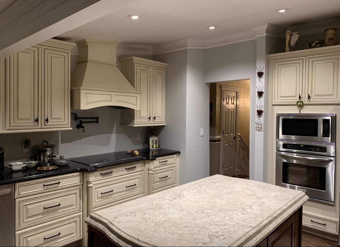 Cream kitchen remodel with custom island and range hood