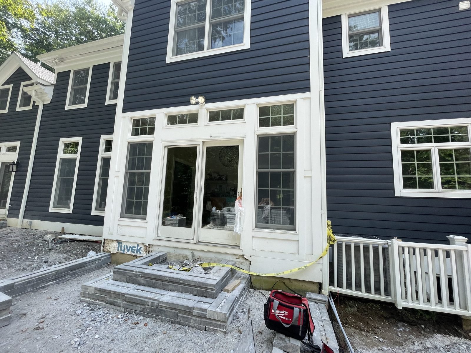 Dark blue sided house with white windows
