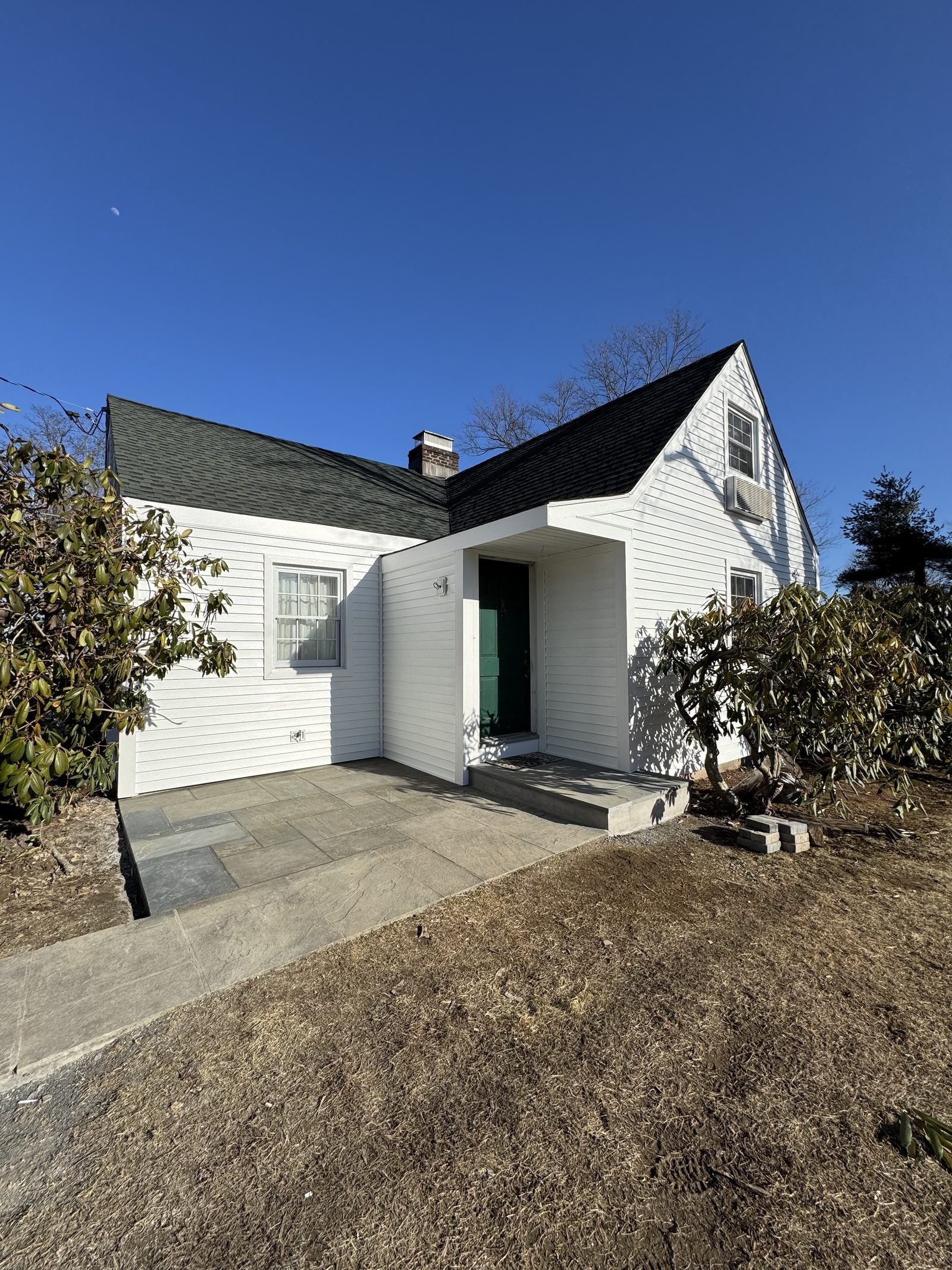 White cape-style home after new vinyl siding installation
